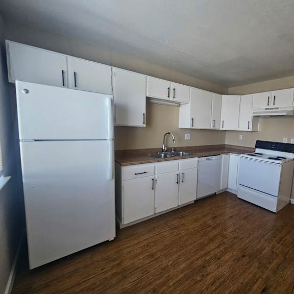 a kitchen with white appliances and cabinets.