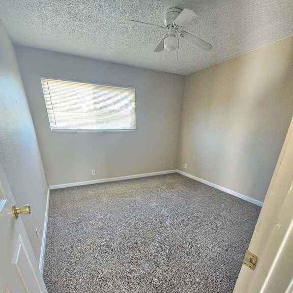 Thumbnail 8 of 14 an empty room with carpet and a ceiling fan