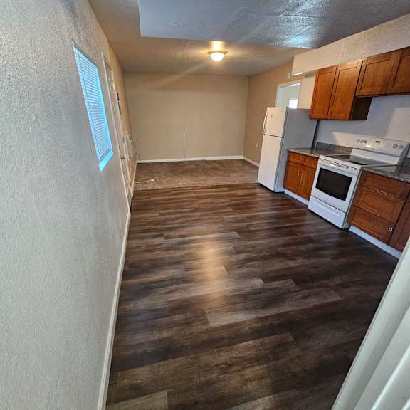 Thumbnail 6 of 14 a kitchen with wood flooring in an empty house
