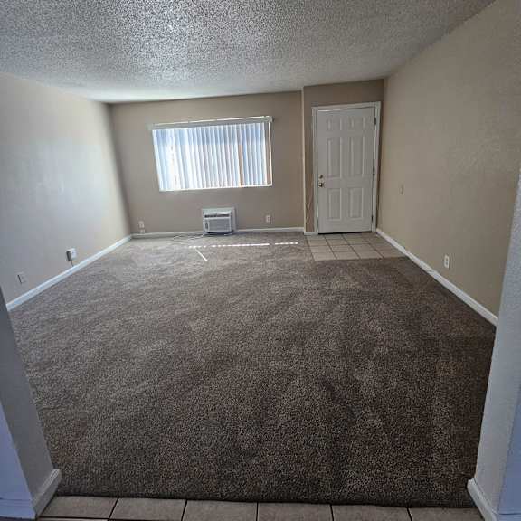 Thumbnail 10 of 14 the living room of an empty house with a carpeted floor