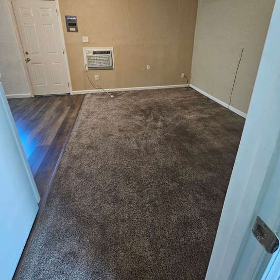 Thumbnail 11 of 14 a empty room with a carpeted floor and a door