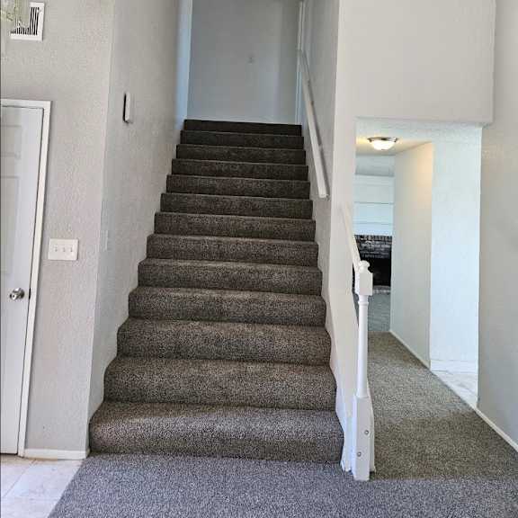 Thumbnail 6 of 12 stairs in a home leading up to a hallway with a door