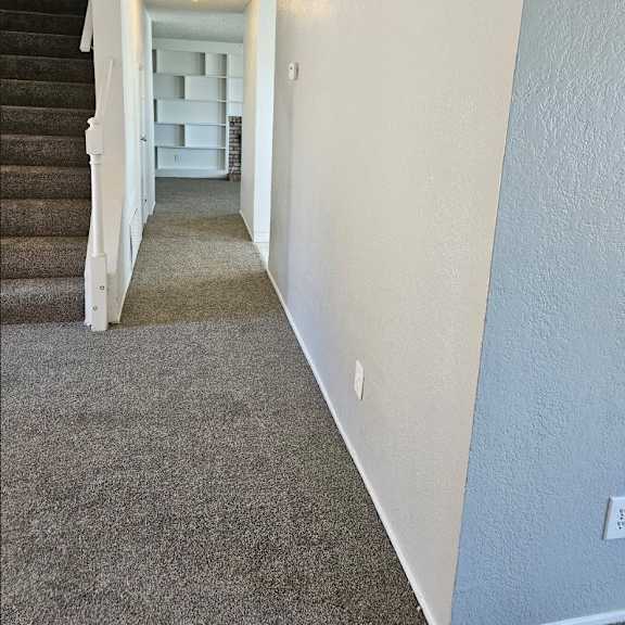 Thumbnail 12 of 12 a carpeted hallway with stairs leading up to a house