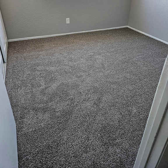 Thumbnail 4 of 12 an empty room with a carpeted floor and a window