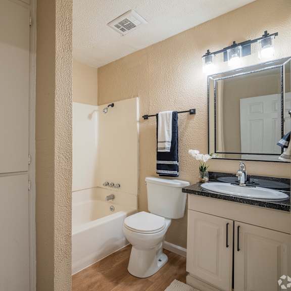Thumbnail 6 of 18 A white toilet sits in a bathroom next to a white sink.