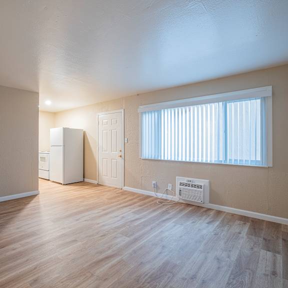 Thumbnail 4 of 18 A room with wooden floors and a window with blinds.