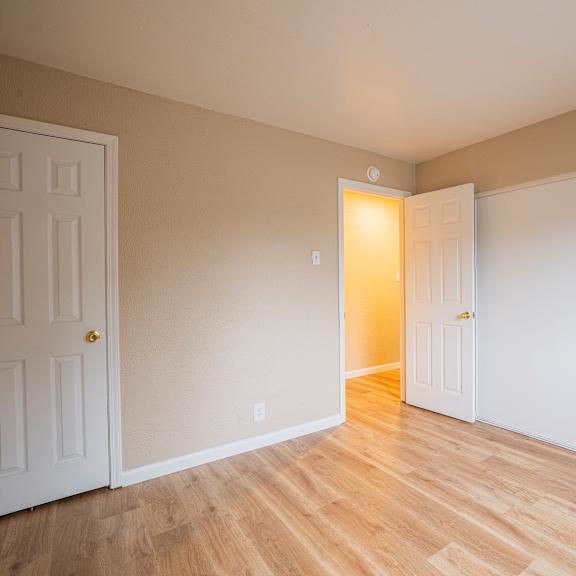 Thumbnail 3 of 18 A room with a white door and a white wall with a light switch.