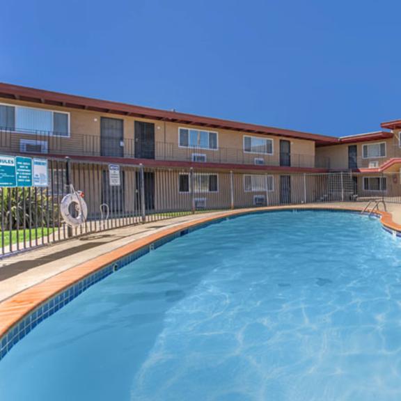 Thumbnail 7 of 19 A swimming pool in front of apartment buildings.