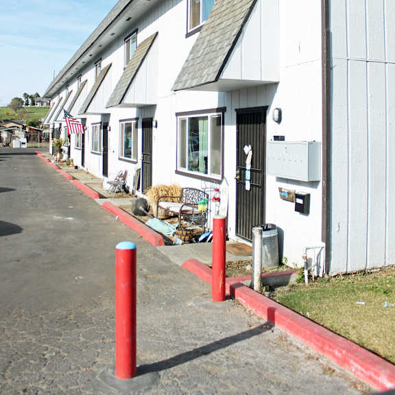 a white building with a red pole in front.