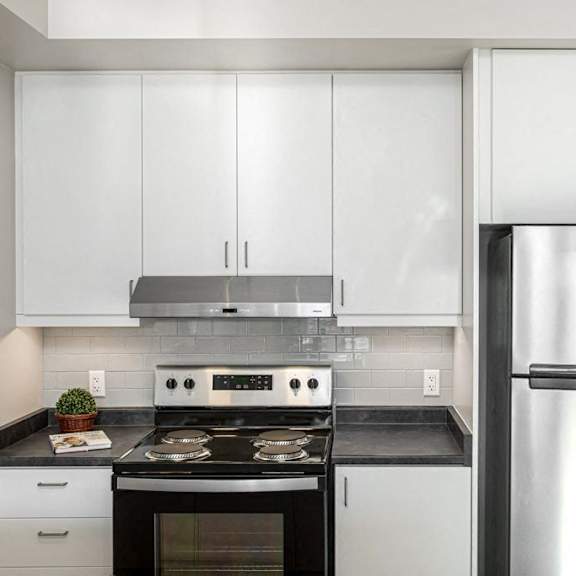 a modern kitchen with a stainless steel refrigerator, oven, and cabinets.