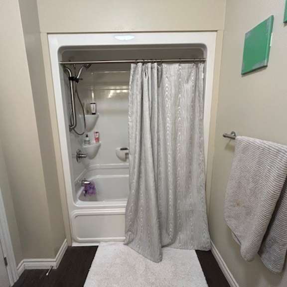 a bathroom with a white shower curtain and a white rug.