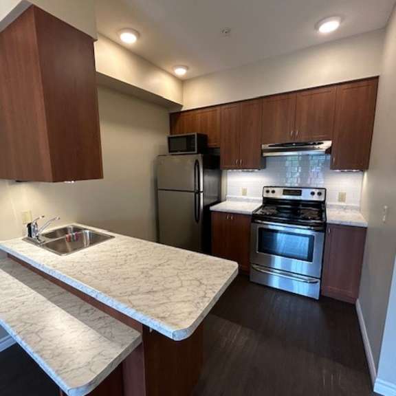 a kitchen with a stove top oven and a sink.