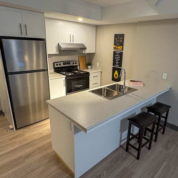 a kitchen with a stainless steel refrigerator and a white countertop.