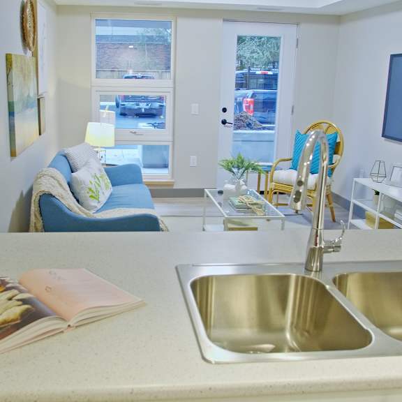 a kitchen with a sink, a book, and a window.