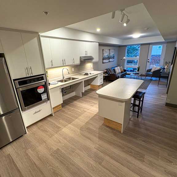 a modern kitchen with a refrigerator, oven, and sink.