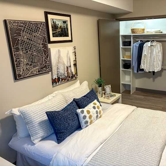 a bedroom with a white bed and a city map on the wall.