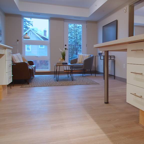 a kitchen with a white counter and a brown chair.