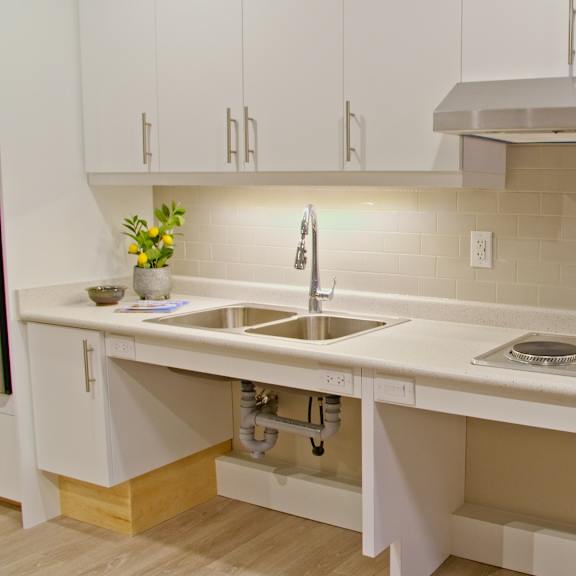 a kitchen with white cabinets and a beige backsplash.