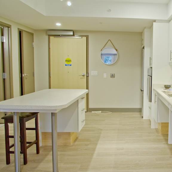 a kitchen with white cabinets and a wooden floor.