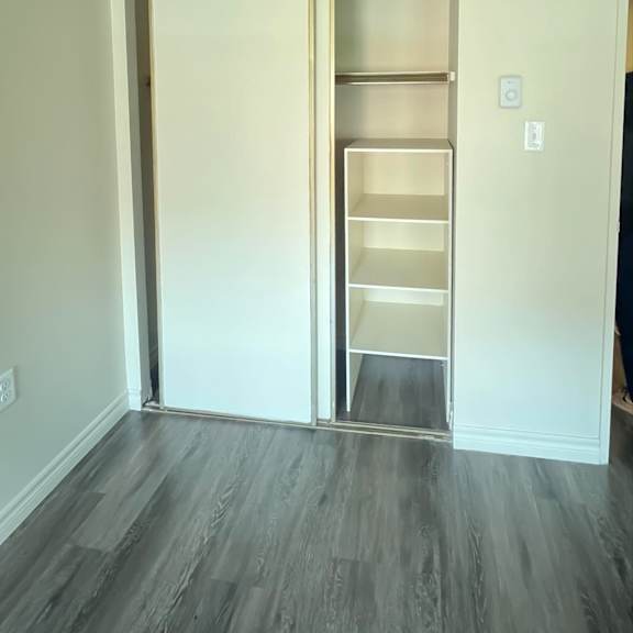 a white door with a shelf is open in a room.