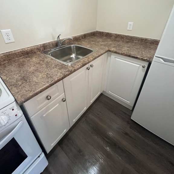 a kitchen with a granite countertop and white appliances.