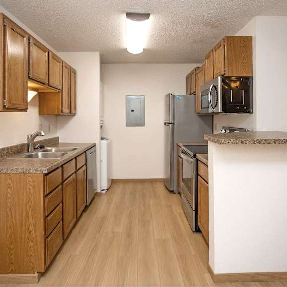 a kitchen with wooden cabinets and a granite counter top.