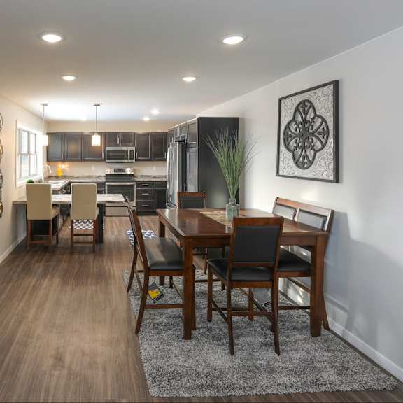 a modern dining room with a wooden table and chairs.