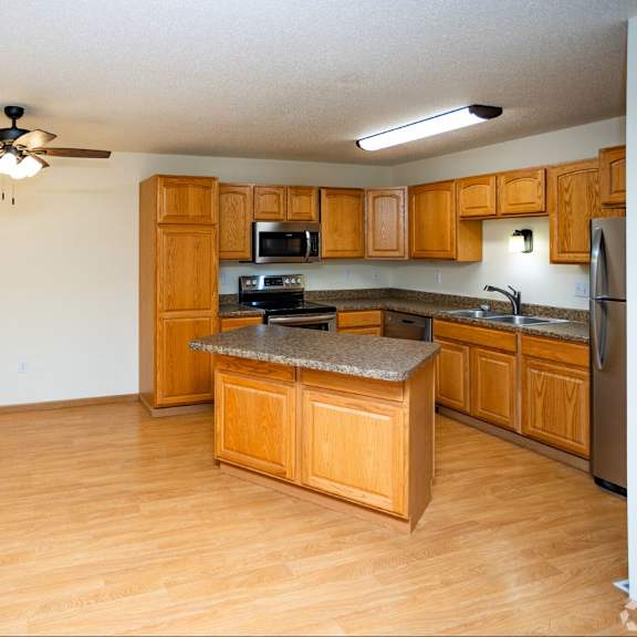a kitchen with wooden cabinets and a granite countertop.