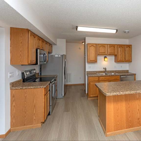 a kitchen with wooden cabinets and a granite counter top.