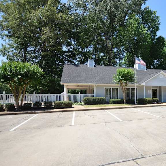 a building with a flag on top and a parking lot in front.