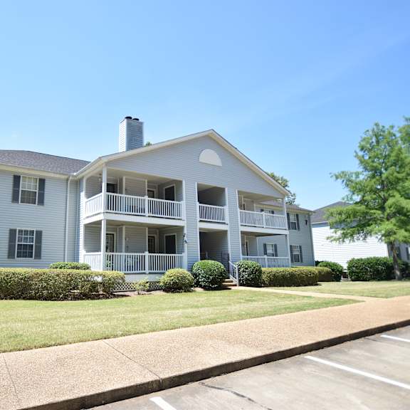 a two-story apartment building with a balcony on the second floor.