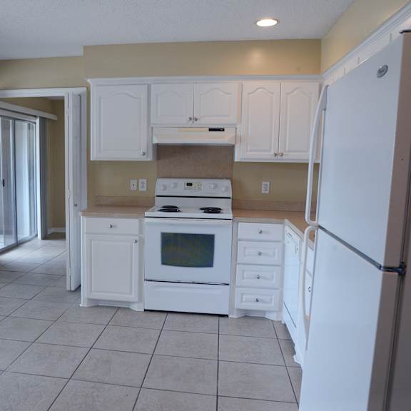 a kitchen with white appliances and cabinets.