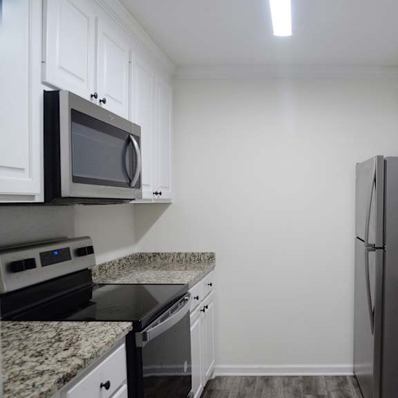 a kitchen with granite countertops and white cabinets.
