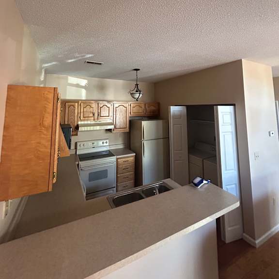a kitchen with white walls and a wooden counter.