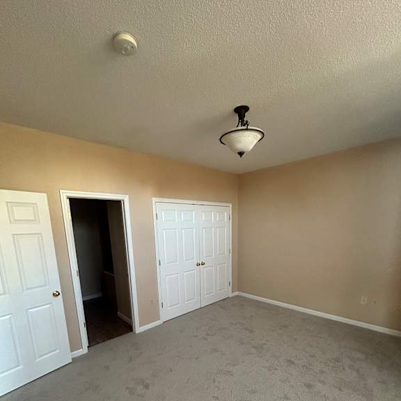 a white door with a small window is in a room with a light on the wall.