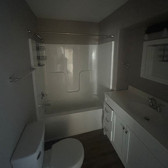 a bathroom with a toilet, sink, and shower.