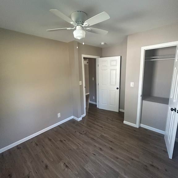 a white ceiling fan is mounted on a wall in a room with a wooden ceiling.