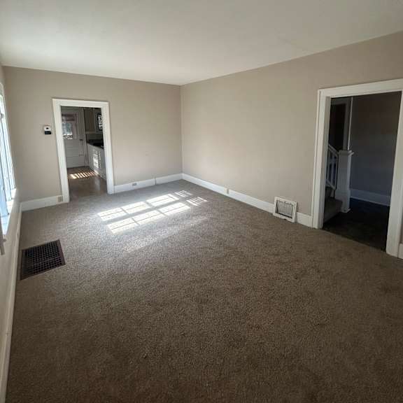 a small window in a room with a white wall and a brown wall.