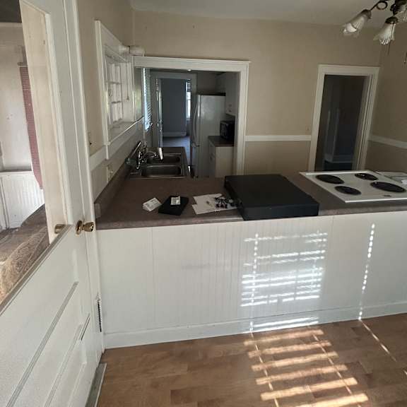 a modern kitchen with a white countertop and a microwave above it.