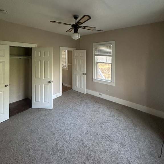 a white ceiling fan is mounted on a white wall.