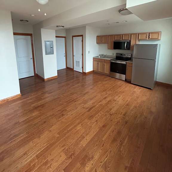 a kitchen with wooden floors and white walls.