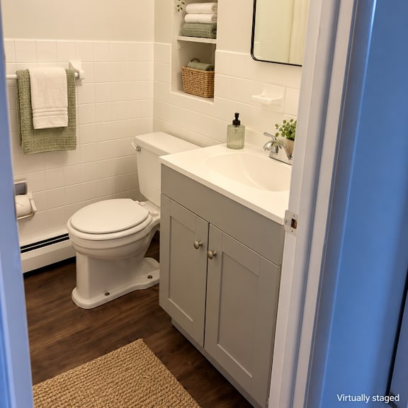 a white toilet sits next to a white sink in a small bathroom.