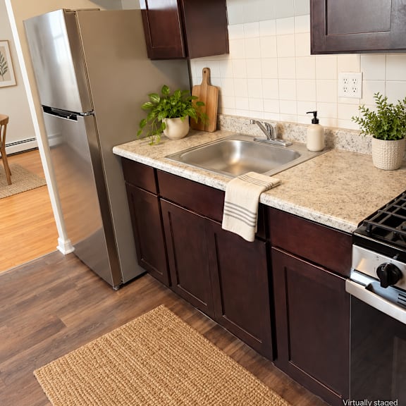 a kitchen with brown cabinets and a stainless steel refrigerator.