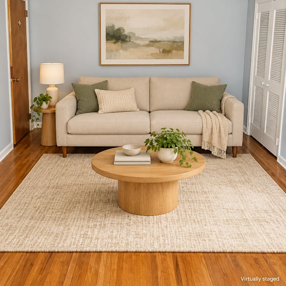 a living room with a couch, a coffee table, and a painting on the wall.