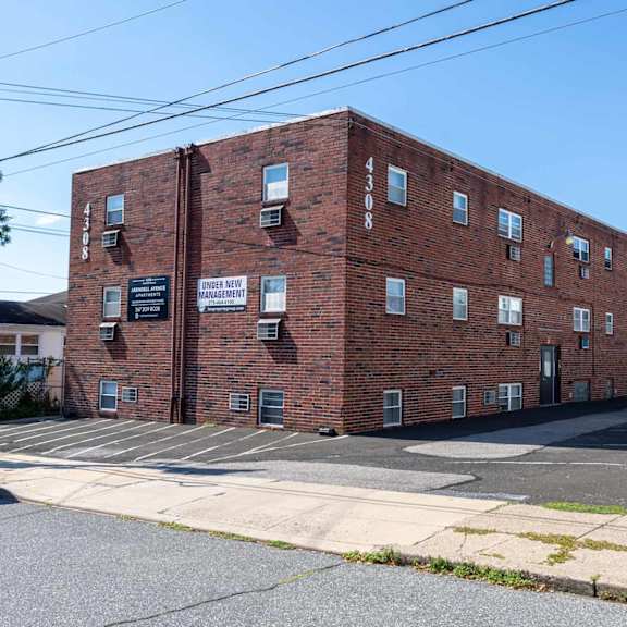 a red brick building with a sign that says "the cottage apartments".