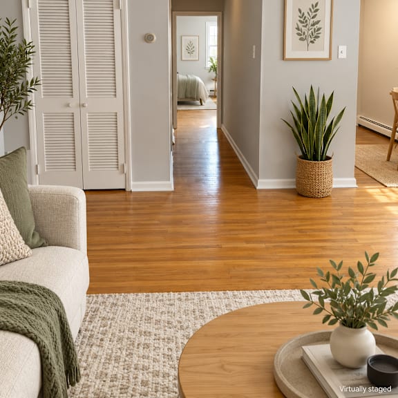 a living room with a couch, a coffee table, and a plant on the table.
