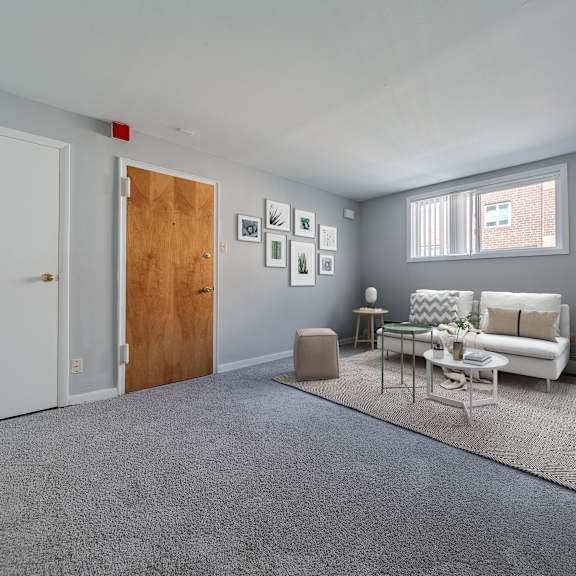 a living room with a grey carpet and a white sofa.