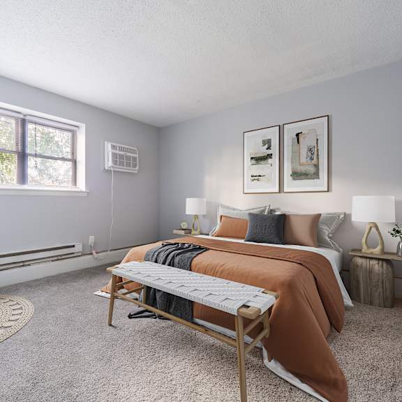 a bedroom with a bed, chair, and window.