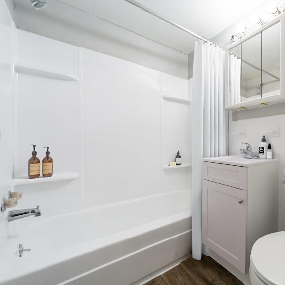 a white bathroom with a toilet, sink, and bathtub.