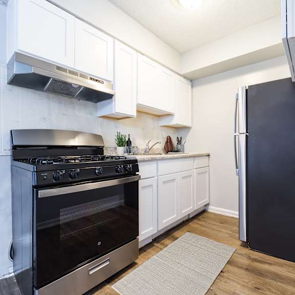 a black oven is in a white kitchen.